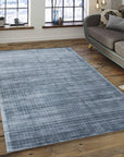 Captivating Lush Blue Handmade Rug, displaying deep blues with subtle texture variations, lies on a light wood floor, adding warmth and depth to a modern space.