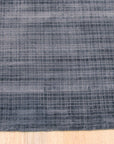 Captivating Lush Blue Handmade Rug displayed in a bright living room setting, showcasing its texture and size. Plush, deep blue tones create a soothing atmosphere, complemented by neutral furniture and natural light.