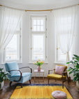 Chic Dazzling Yellow Flatweave Wool Rug brightens a living room space, its flatweave construction adding texture beneath a modern coffee table, with hints of yellow echoing in decorative pillows.