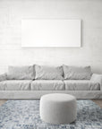 Tessa Sophisticated Gray Hand Knotted Wool Rug gracing a bright, modern living room. Neutral furniture complements the rug's subtle gray tones and hand-knotted texture, creating a calming and elegant space.