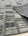 Tessa Sophisticated Gray Hand Knotted Wool Rug, showcasing its subtle grey tones and intricate hand-knotted texture under warm interior lighting.