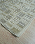 Freya Timeless Ivory Hand Knotted Wool Rug, a plush landscape of creamy ivory, graces a sun-drenched living space, its intricate hand-knotted texture inviting bare feet and relaxed moments.