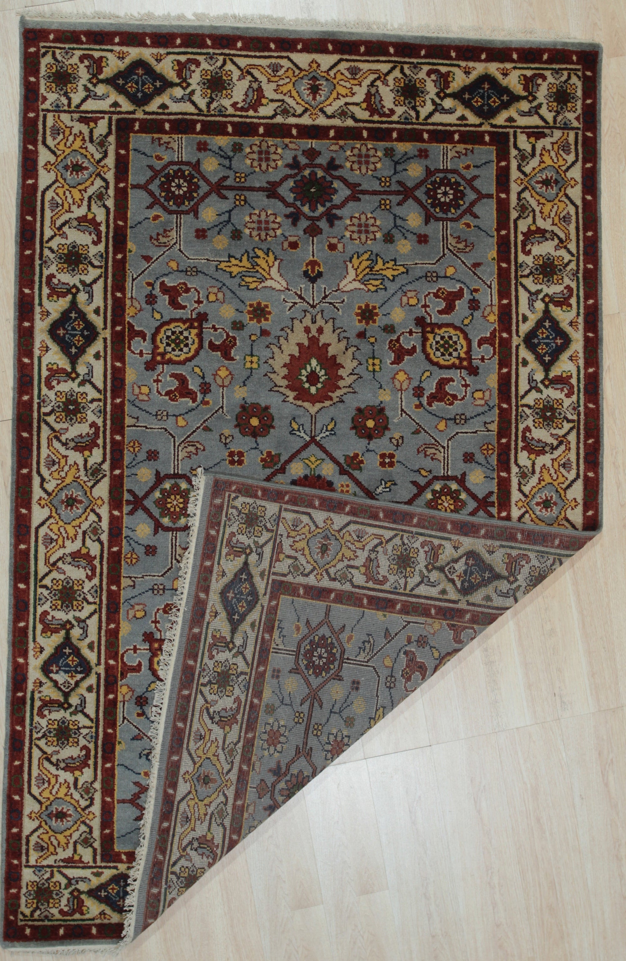 Vibrant Oriental Blue Hand Knotted Wool Rug, showcasing a rich blue field and intricate floral patterns, displayed in a bright, modern living room.
