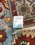 Vibrant Oriental Blue Hand Knotted Wool Rug displayed in a well-lit living space, its intricate floral motifs and deep blues adding a touch of classic elegance to the room.