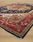 Ella Oriental Navy Hand Knotted Wool Rug, showcasing its intricate navy and ivory design under warm lighting, creating a rich and inviting texture.