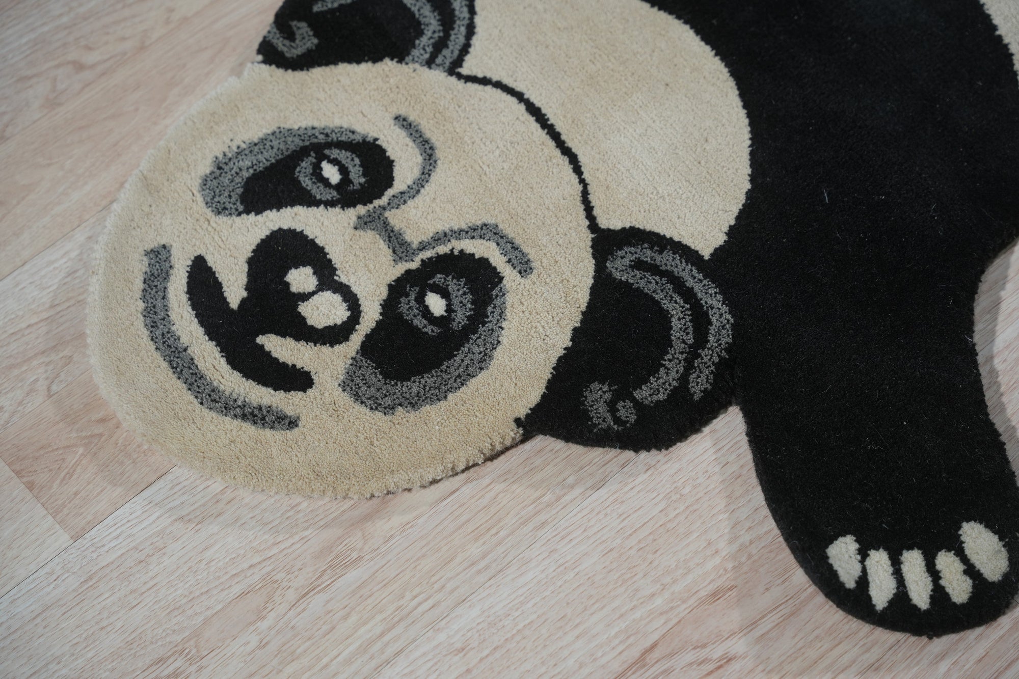 Brenda Clara Black & White Hand Tufted Wool Rug, a bold graphic statement in monochromatic wool, sits centered on a polished wooden floor, inviting touch with its textured surface and contrasting geometric patterns.