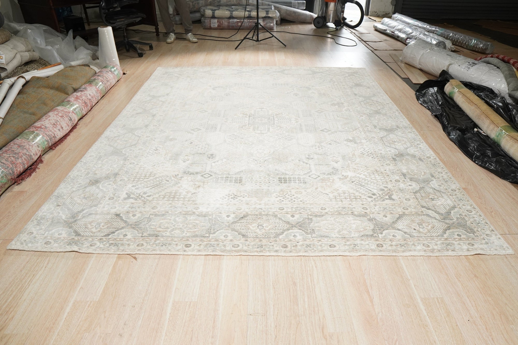 Tessa Bespoke Green Handmade Wool Rug, a lush verdant expanse of hand-knotted wool, lies on a light wood floor, its texture subtly catching the light, offering a sense of natural tranquility.