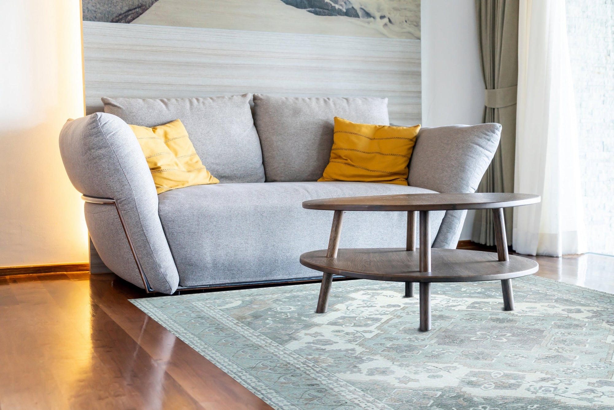 Selene Oriental Green Handmade Wool Rug graces a warmly lit living room. The hand-knotted wool rug, a vibrant blend of greens and earthy tones, anchors a space with a mid-century modern aesthetic. Sunlight highlights the intricate oriental pattern and plush texture under a stylish coffee table.