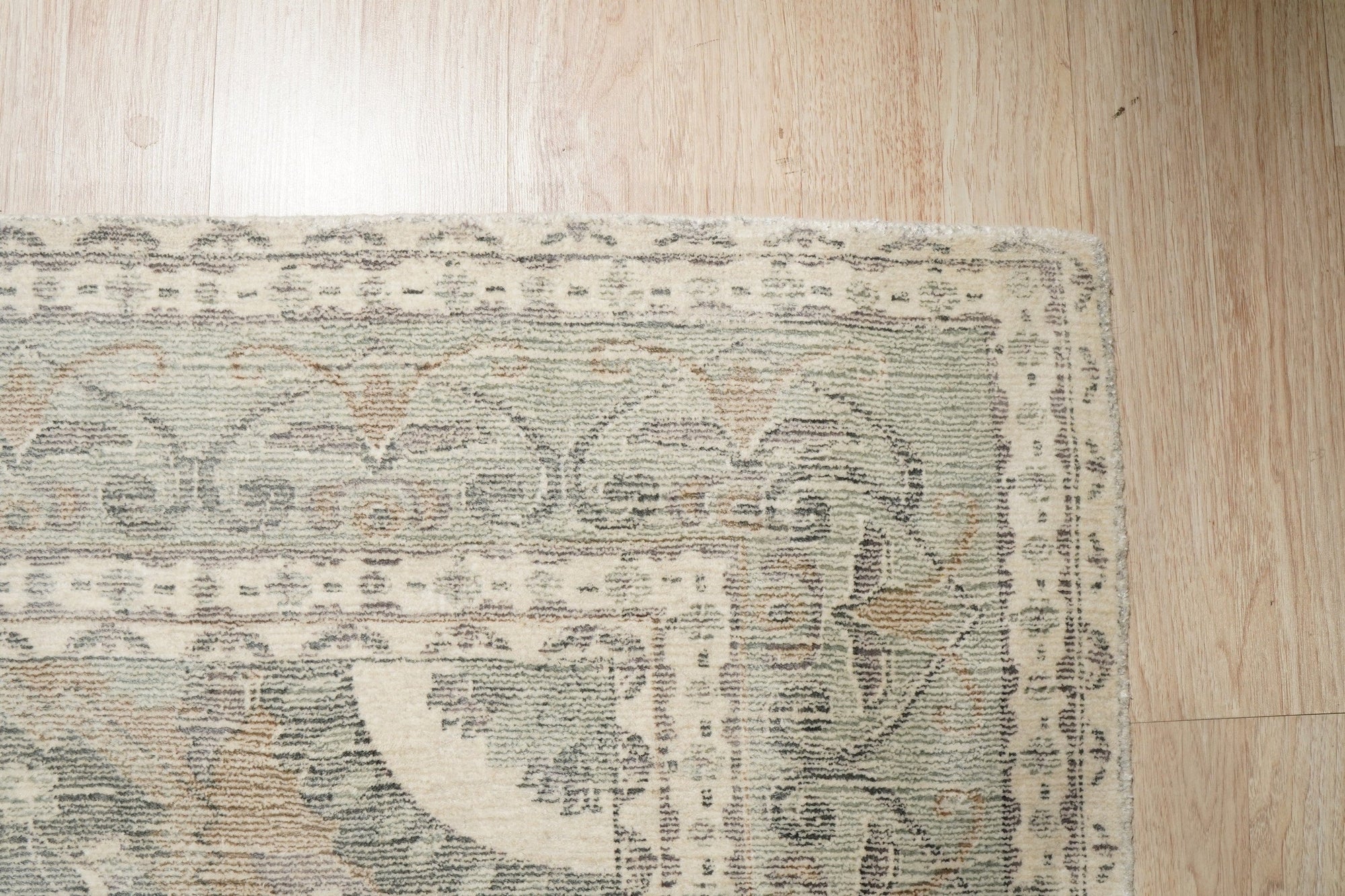 Selene Oriental Green Handmade Wool Rug, vibrant green wool rug with intricate oriental patterns, warmly lit in a living room setting.