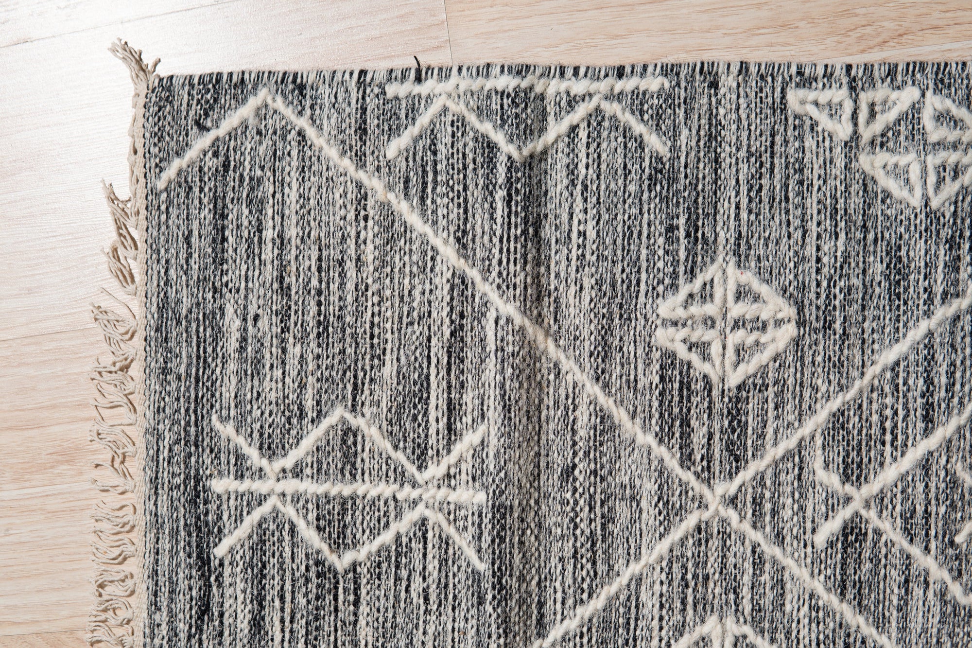 Luxurious Kilim Charcoal Handmade Wool Rug, displaying tightly woven charcoal wool in a classic Kilim design, presented in a bright, modern living space.