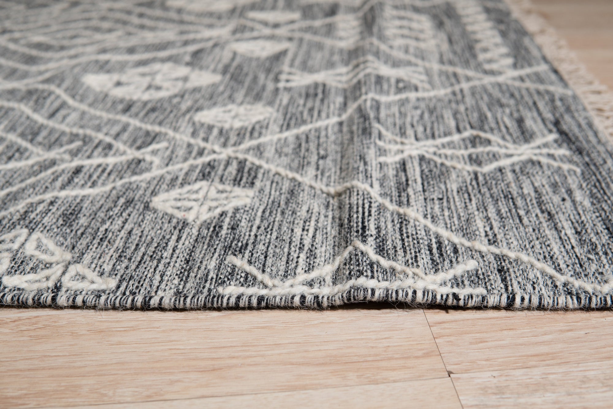 Luxurious Kilim Charcoal Handmade Wool Rug, textural wool weaves create depth and shadow in this charcoal grey rug, its kilim design adding artisanal warmth to a modern living space.