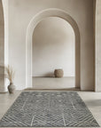 Luxurious Kilim Charcoal Handmade Wool Rug, a sophisticated charcoal wool rug with a geometric Kilim design, laid on a light wooden floor, showcasing its texture and scale within an interior space.