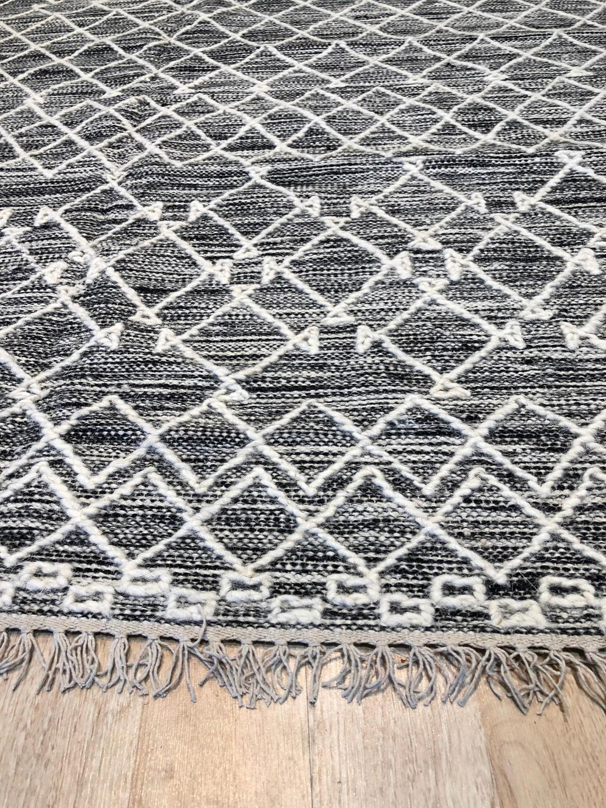 Penelope Kilim Brown Handmade Wool Rug, warm earthy tones and geometric patterns dance across this hand-woven wool rug, adding rustic charm to a contemporary living space with light hardwood floors.