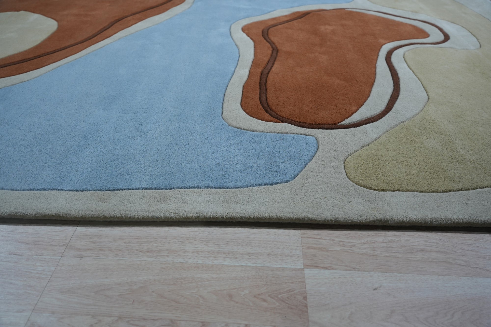 Yara Rustic Blue Hand Tufted Wool Rug, warm ambiance featuring a textured wool rug with a rustic blue palette, complementing a contemporary living space.