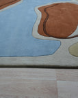 Yara Rustic Blue Hand Tufted Wool Rug, warm ambiance featuring a textured wool rug with a rustic blue palette, complementing a contemporary living space.