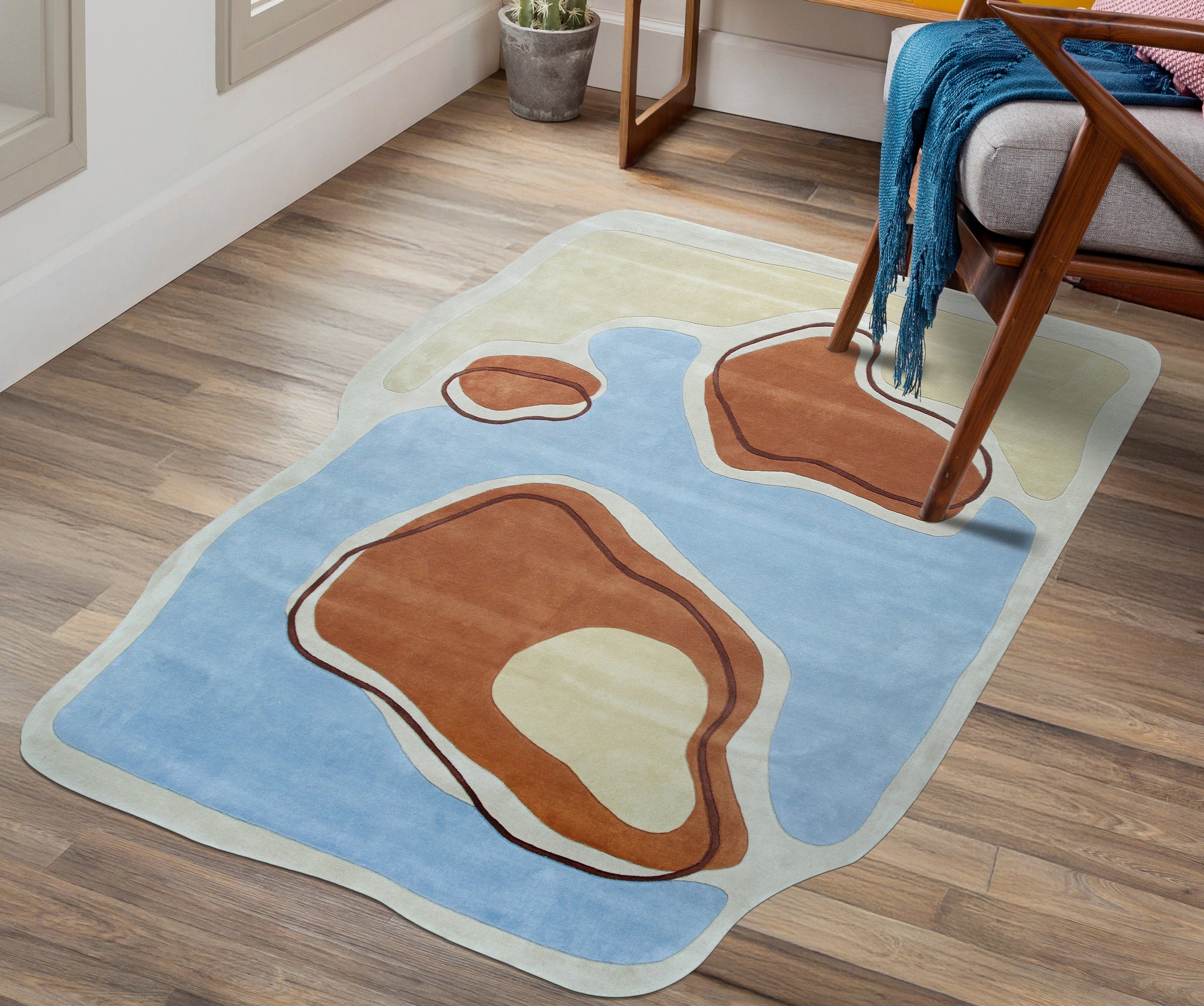 Yara Rustic Blue Hand Tufted Wool Rug, anchoring a living room space with its textured wool construction and subtle blue hues, complements warm wood tones and natural light, suggesting comfortable, everyday living.