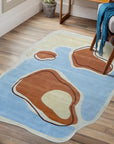 Yara Rustic Blue Hand Tufted Wool Rug, anchoring a living room space with its textured wool construction and subtle blue hues, complements warm wood tones and natural light, suggesting comfortable, everyday living.