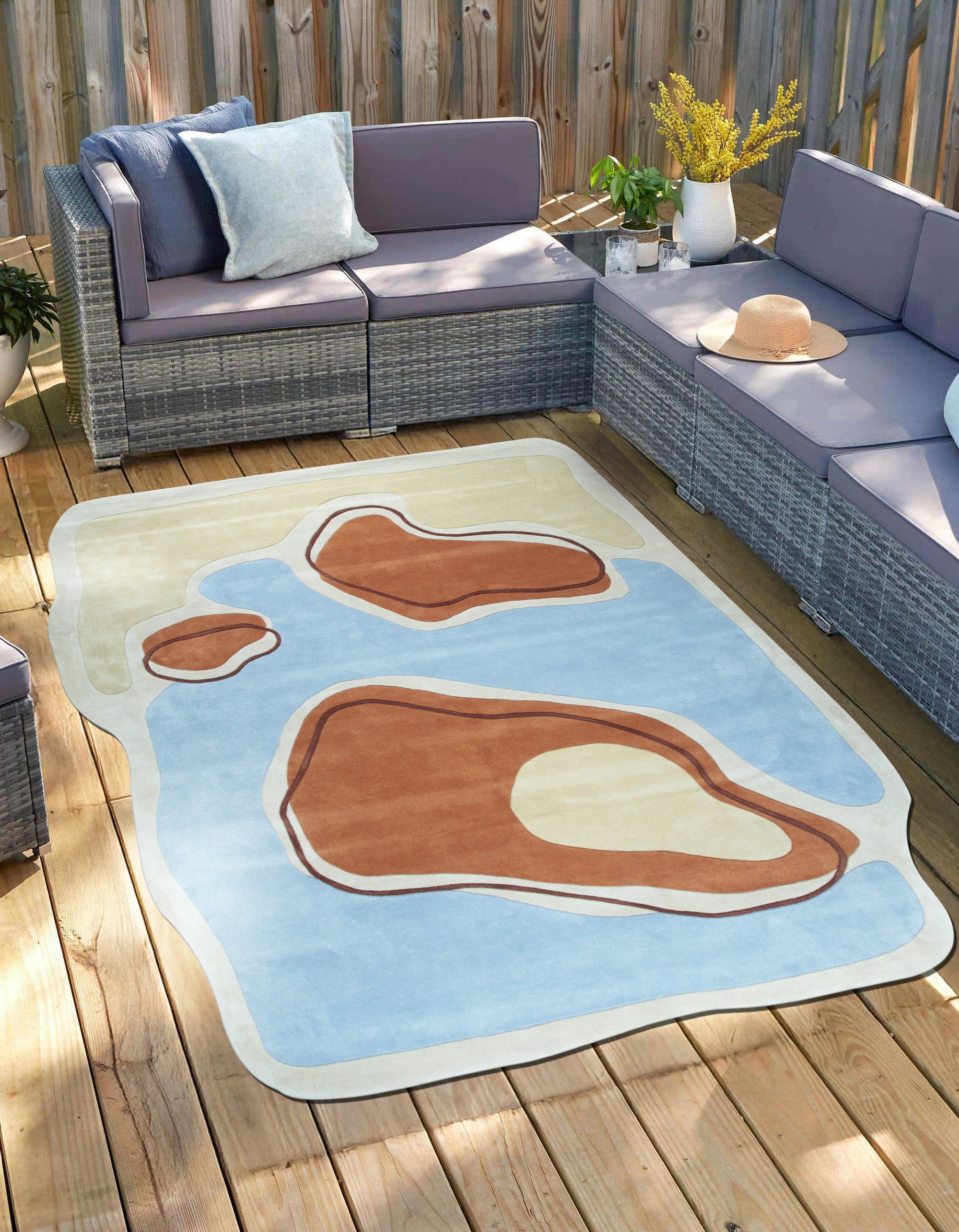 Yara Rustic Blue Hand Tufted Wool Rug, showcasing a textured surface and muted blue hues, adds warmth to a softly lit room with minimalist furniture.