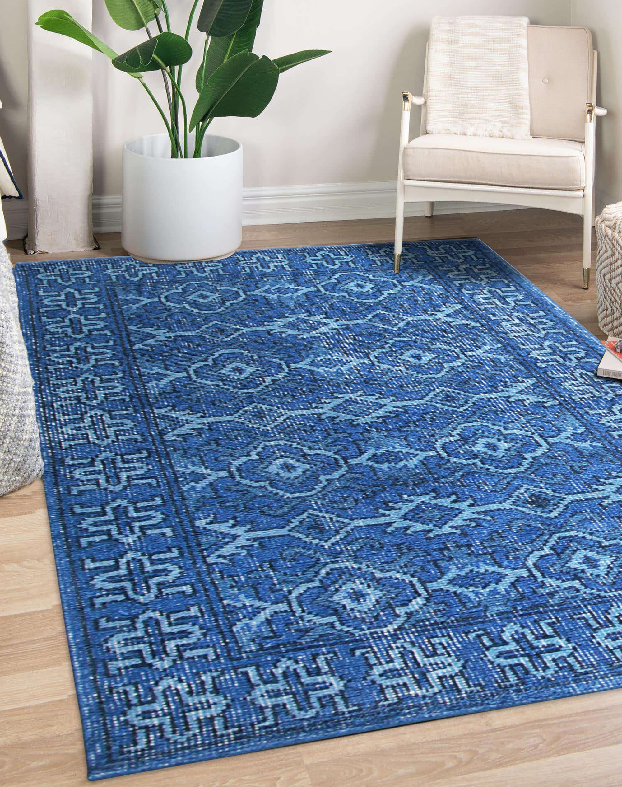 Mira Traditional Blue Hand Knotted Wool Rug, a field of rich blues and intricate patterns, anchors a warmly lit living space. Hand-knotted wool fibers create a textured surface, showcasing the rug's traditional design and vibrant color palette in a lived-in setting.