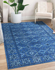Mira Traditional Blue Hand Knotted Wool Rug, a field of rich blues and intricate patterns, anchors a warmly lit living space. Hand-knotted wool fibers create a textured surface, showcasing the rug's traditional design and vibrant color palette in a lived-in setting.