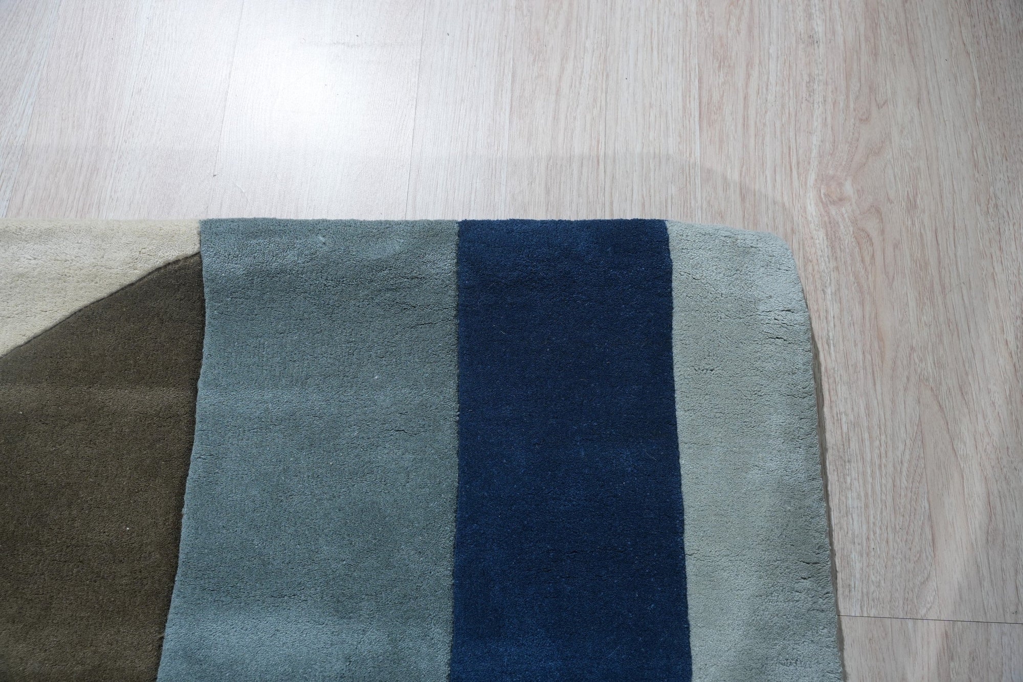 Bespoke Iris Multicolor Hand Tufted Wool Rug, its vibrant hues blooming across a modern living room, softening the space with hand-tufted texture.