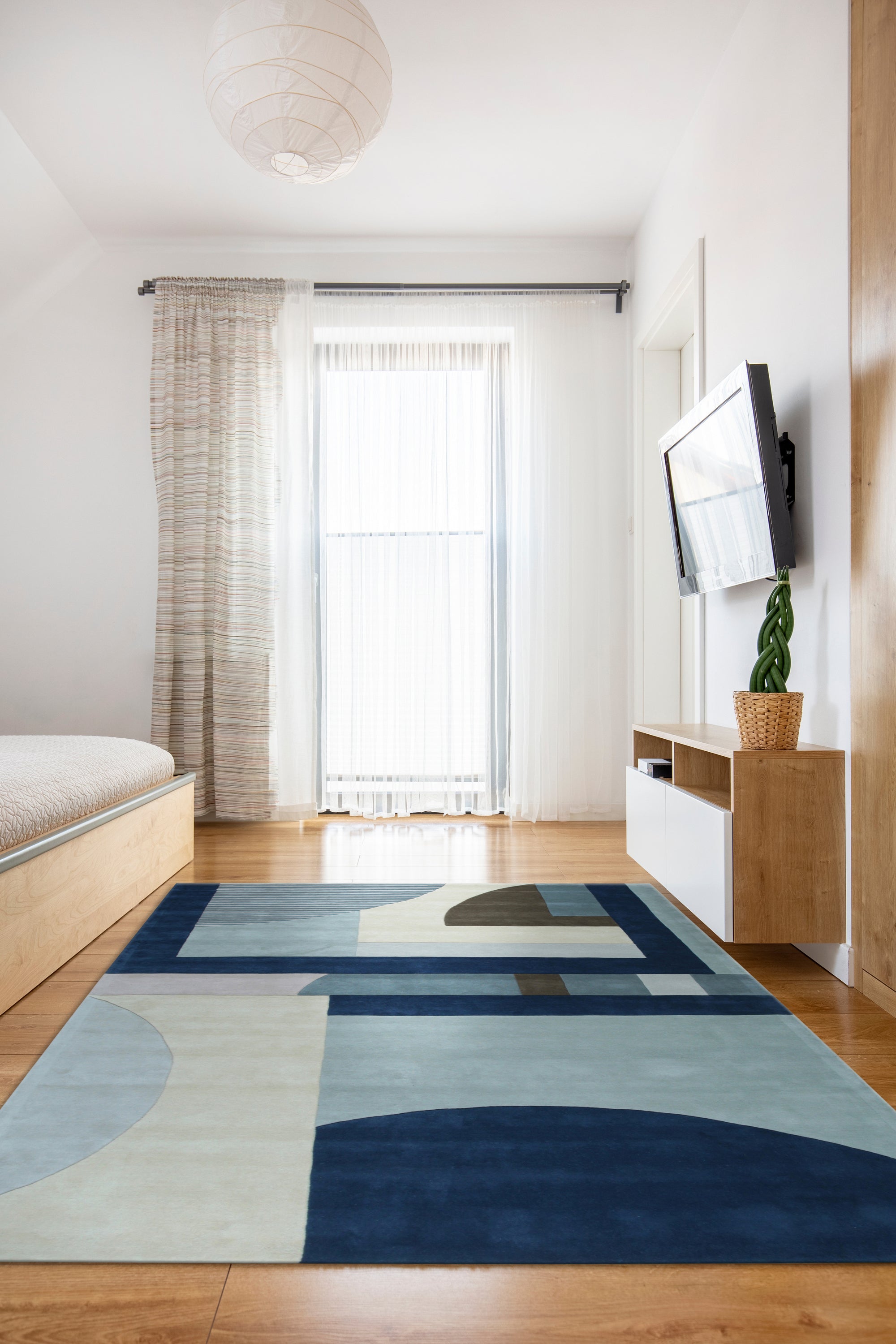 Bespoke Iris Multicolor Hand Tufted Wool Rug, showcasing a vibrant abstract floral pattern in a contemporary living room setting.