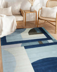 Bespoke Iris Multicolor Hand Tufted Wool Rug, vibrant waves of blues, purples, greens, and creams cascade across a luxuriously textured wool surface, viewed in a styled living room setting.