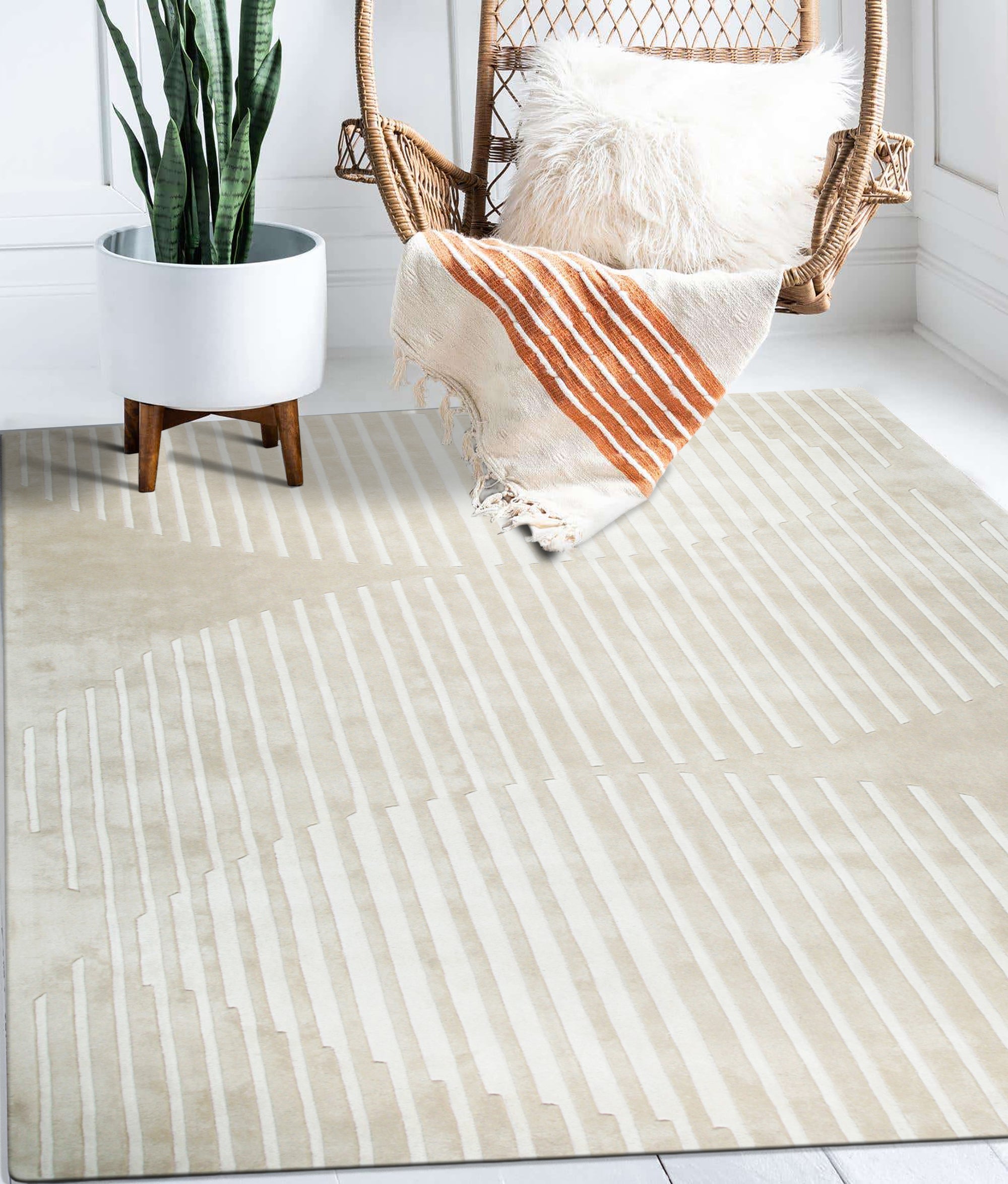 Maya Bianca Beige Hand Tufted Wool Rug, a soft beige wool rug with subtle texture, complements a bright living room with natural light and modern furniture.