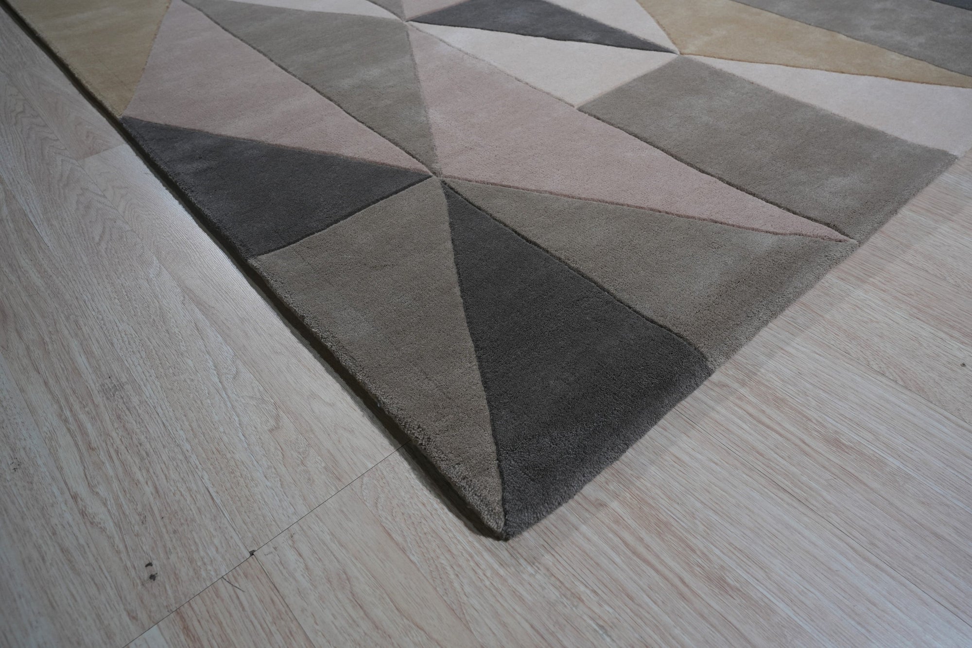 Given the image position is 4, here's the alt text:
 
 Trendy Classic Multicolor Hand Tufted Wool Rug, its vibrant geometric pattern pops against a light wood floor, showcasing the rug's textured weave and diverse color palette.