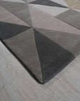 Given the image position is 4, here's the alt text:
Trendy Classic Multicolor Hand Tufted Wool Rug, its vibrant geometric pattern pops against a light wood floor, showcasing the rug's textured weave and diverse color palette.