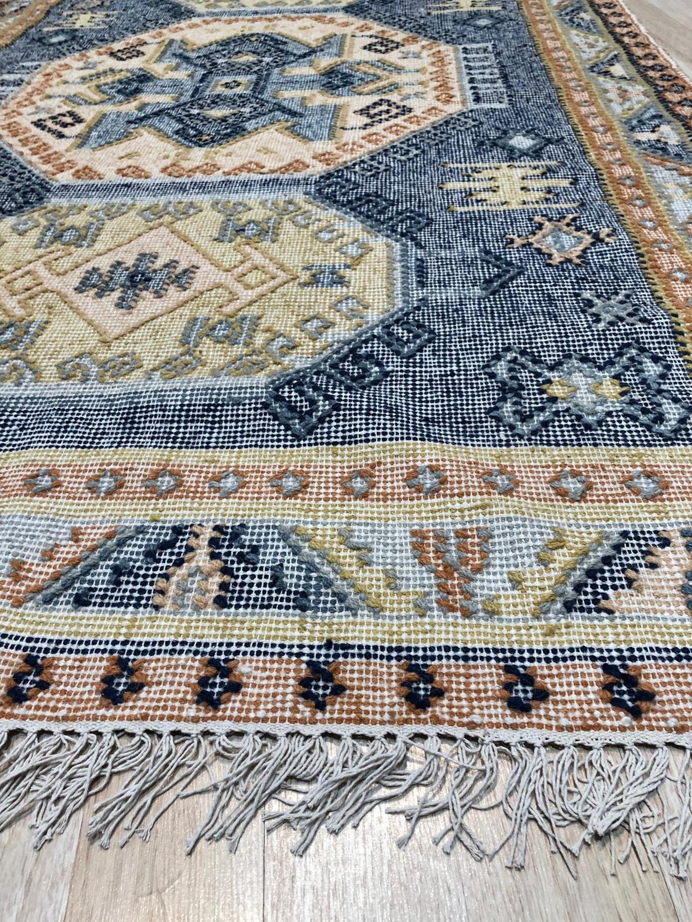 Luna Kilim Blue Hand Knotted Wool Rug, a blue wool rug featuring a geometric Kilim design, softly illuminated in a well-lit interior setting.