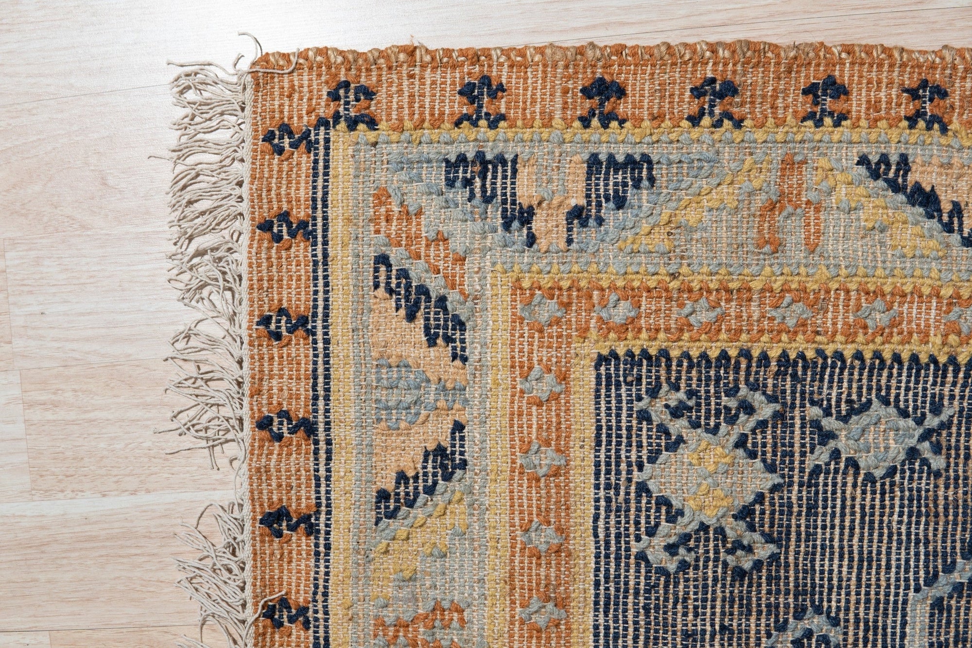 Luna Kilim Blue Hand Knotted Wool Rug, its geometric kilim patterns unfolding in shades of blue, accenting a softly lit interior.