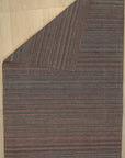 Fiona Striped Navy Handmade Rug, showcasing wide navy and off-white stripes in a natural fiber weave, positioned on a light hardwood floor with a neutral wall backdrop.