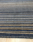 Fiona Striped Navy Handmade Rug, soft navy and cream stripes cascade across this handwoven rug, adding a relaxed, coastal vibe to a bright living space.