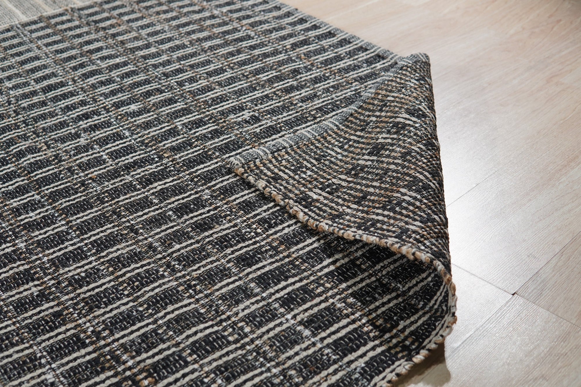 Lila Talia Gold Flatweave Rug, its shimmering gold threads catching the light in a warm, inviting living room setting. The flatweave construction allows for a low pile and contemporary feel, complementing modern furniture.