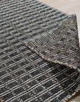 Lila Talia Gold Flatweave Rug, its shimmering gold threads catching the light in a warm, inviting living room setting. The flatweave construction allows for a low pile and contemporary feel, complementing modern furniture.