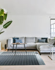 Clara Xena Charcoal Flatweave Wool & Cotton Rug, its deep charcoal hues and flatweave construction displayed in a bright, airy living room setting.