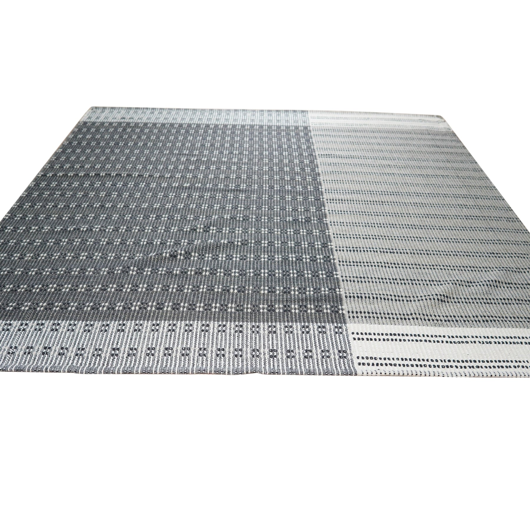 Clara Xena Charcoal Flatweave Wool & Cotton Rug, a charcoal-colored flatweave rug blending wool and cotton textures, displayed in a styled room setting with neutral furniture and warm lighting.