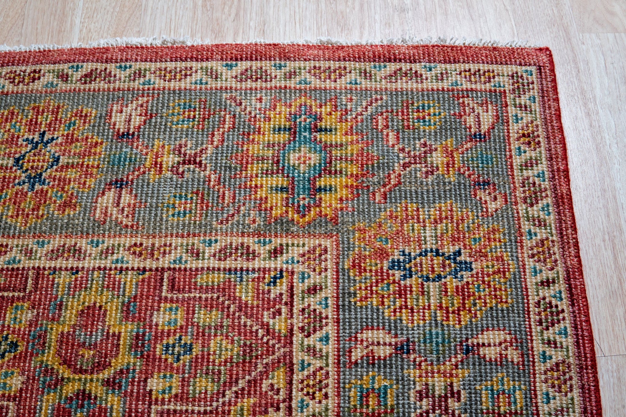 Celia Oushak Rust Hand Knotted Wool Rug, a warm rust and cream hand-knotted wool rug with a classic Oushak design, anchors a living space, its soft texture inviting bare feet.