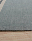 Opulent Majestic Blue Flatweave Wool Rug, its deep blues and intricate flatweave pattern grounding a bright, modern living room with light wood floors and textured cream sofa.