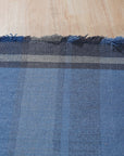 Maya Opulent Blue Flatweave Wool Rug, a rich blue wool rug with a subtly textured flatweave, lies on a light hardwood floor.