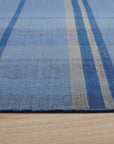 Maya Opulent Blue Flatweave Wool Rug, a serene expanse of indigo and sapphire hues woven in a durable flatweave construction, offers textural richness and modern elegance underfoot.