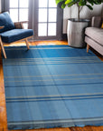 Maya Opulent Blue Flatweave Wool Rug, showcasing a modern pattern with varying shades of blue and cream, displayed in a bright, airy living room setting.