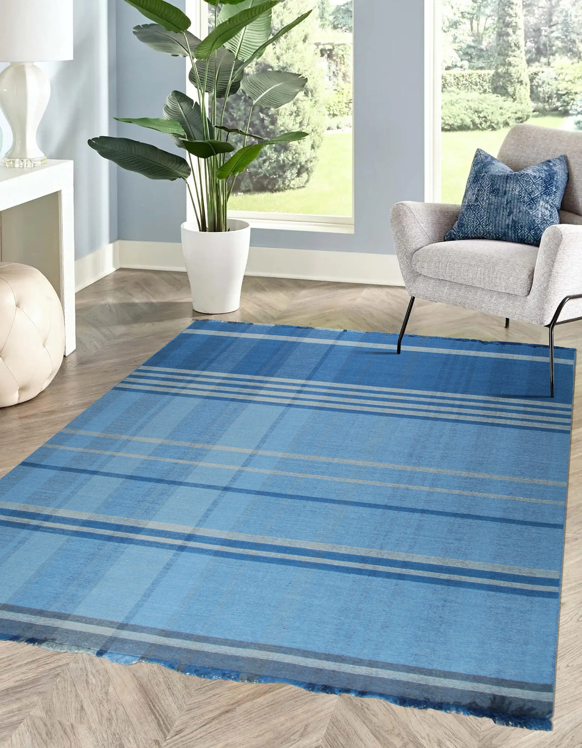 Maya Opulent Blue Flatweave Wool Rug, a richly textured wool rug in shades of blue, displayed in a bright, contemporary living room setting, complementing neutral furniture.