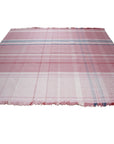 Maya Giselle Pink Flatweave Wool Rug, showcasing a modern geometric design in shades of pink and cream, subtly textured within a bright, airy living room setting.