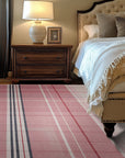 Maya Giselle Pink Flatweave Wool Rug, a soft pink wool rug with a subtle, geometric flatweave design, displayed on a light hardwood floor.