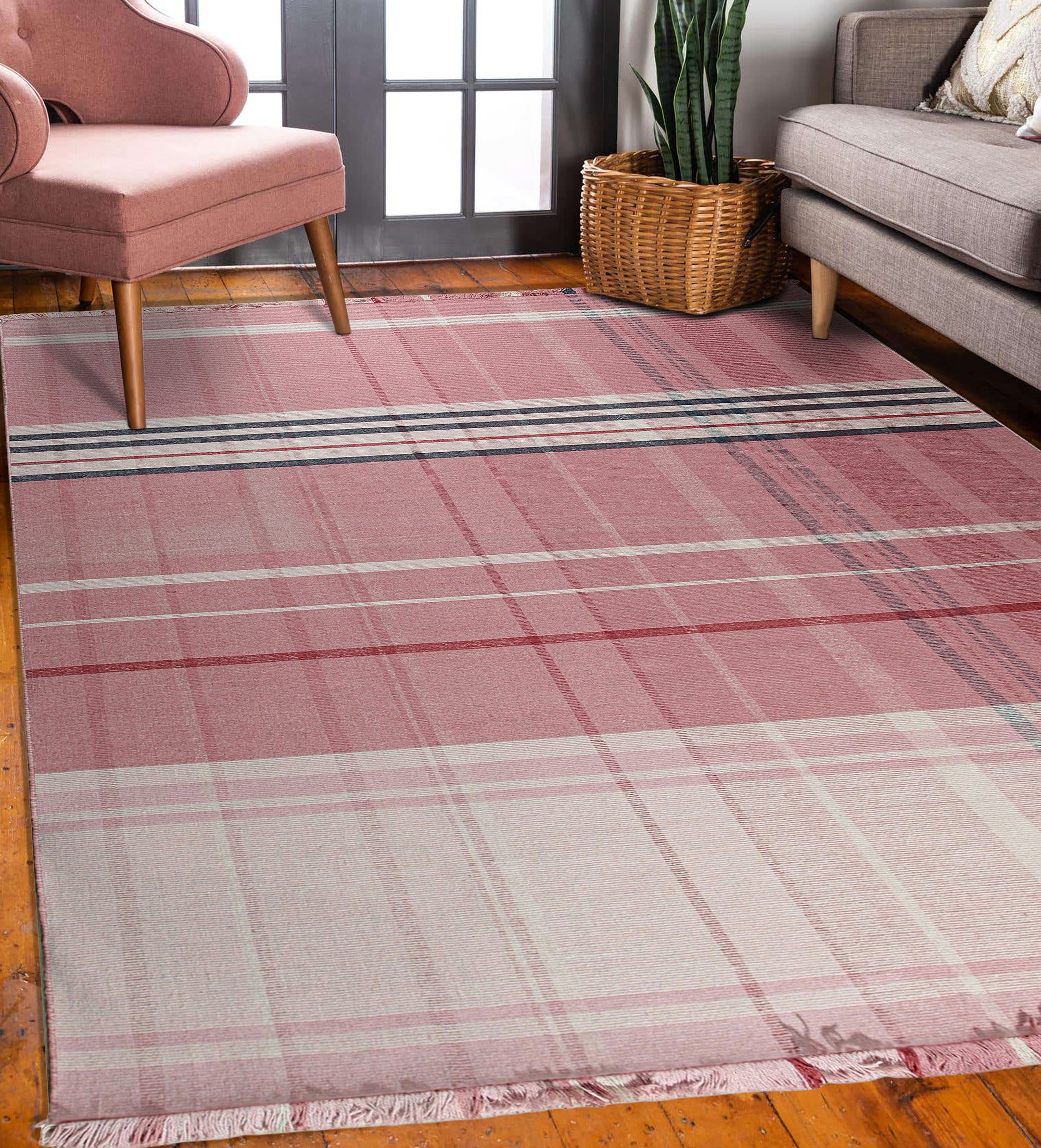 Maya Giselle Pink Flatweave Wool Rug displayed in a bright, modern living room setting. Soft pink hues and a subtle geometric pattern define this flatweave wool rug, grounding a seating area with a natural and inviting texture.