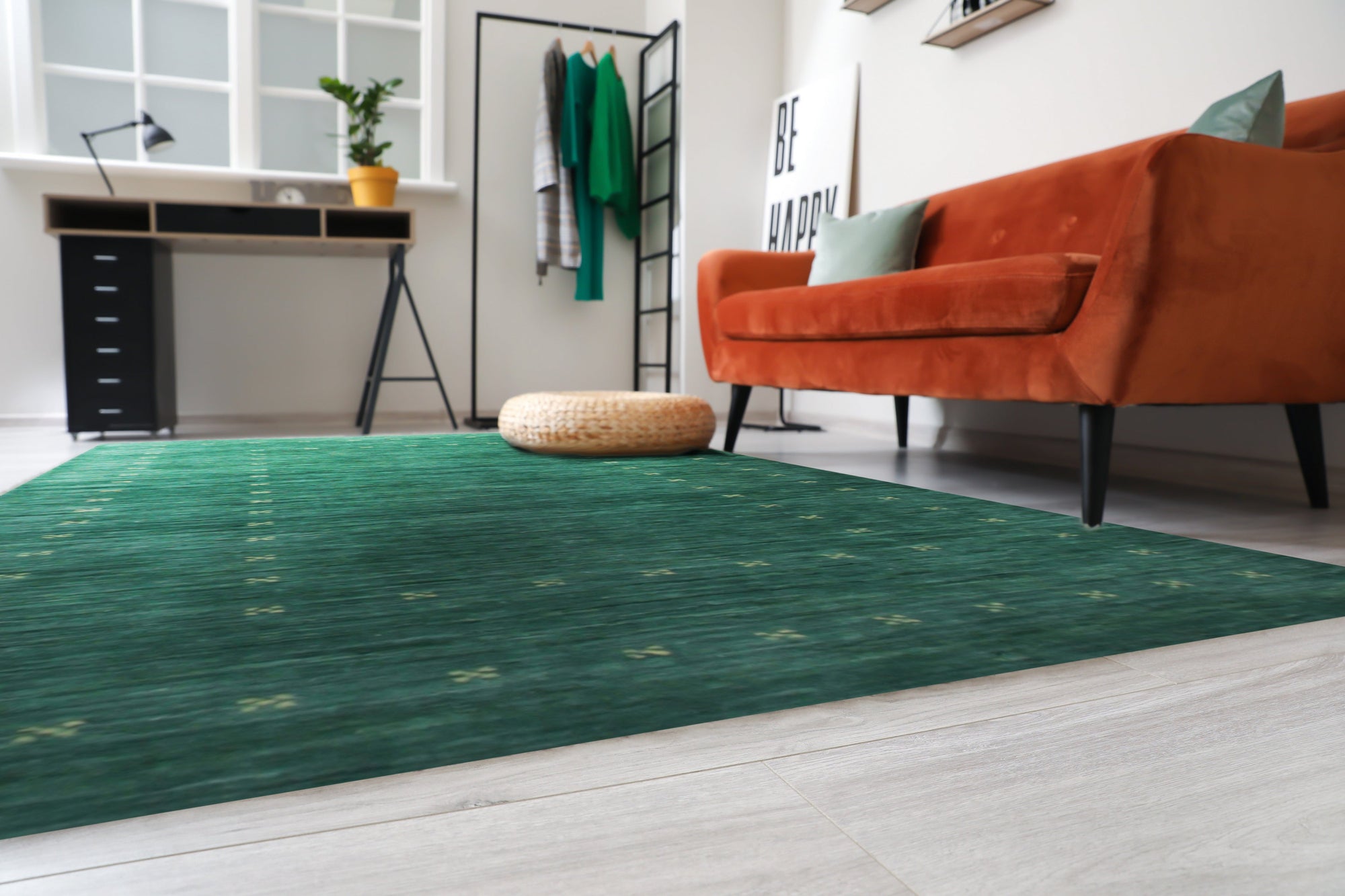Sloane Ava Green Handmade Wool Rug, featuring muted green tones and subtle geometric patterns, complements a bright living space with natural light and minimalist decor.