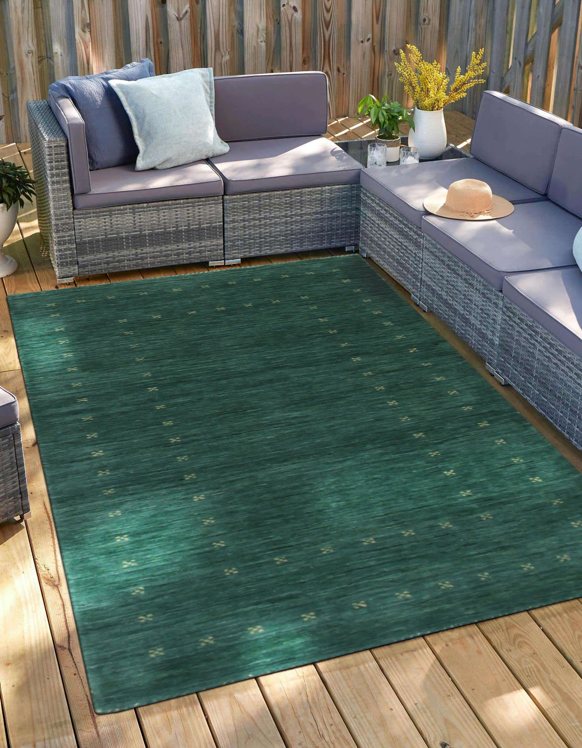 Sloane Ava Green Handmade Wool Rug, showcasing its subtle textured surface and calming green hues, lending a touch of earthy sophistication to a well-lit living space.