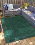 Sloane Ava Green Handmade Wool Rug, showcasing its subtle textured surface and calming green hues, lending a touch of earthy sophistication to a well-lit living space.
